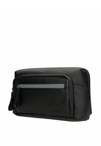 Czarna teksturowana torba podróżna na kosmetyki z przednią kieszenią na zamek błyskawiczny i materiałowym paskiem na nadgarstek na białym tle.