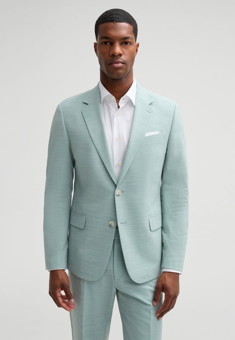 Light green suit with a textured finish, featuring a two-button closure, notched lapels, and side pockets. White shirt underneath.