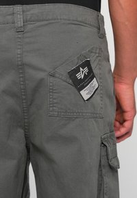 Grijze cargobroek met een achterzak met label, versterkte stiksels en een geweven katoen stof. Het ontwerp omvat zijzakken voor functionaliteit.