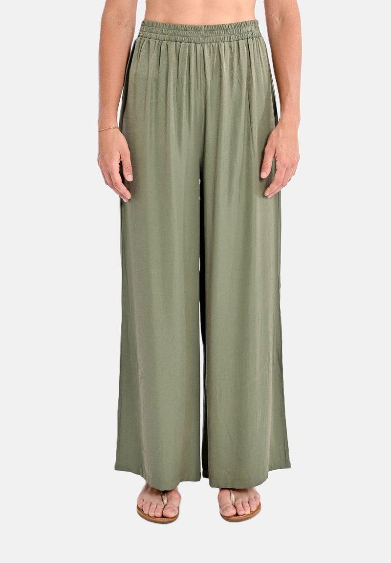 Pantaloni larghi in tessuto verde oliva, con una cintura elastica. Texture morbida con una caduta fluida. Abbinati a sandali piatti.