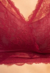 Burgundy Spitzen-Bralette mit floralen Mustern, einem V-Ausschnitt und gewellten Kanten sowie einem weichen Band für Unterstützung.