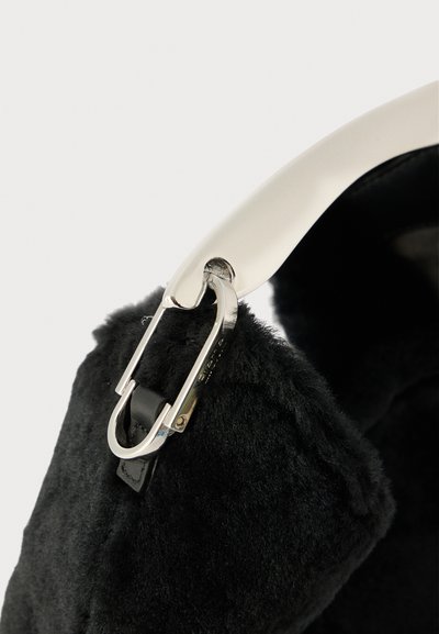 Bolso de piel sintética negra con un elegante cierre de hardware plateado y un acento de cuero suave cerca del asa. Diseño texturizado y compacto.