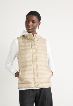 Beige Kapuzen-Pufferweste mit Reißverschluss und Druckknöpfen, mit gestepptem Muster und seitlichen Taschen, getragen über einem weißen Hoodie.