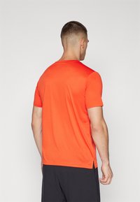 New Balance ESSENTIALS - Sport T-Shirt - neo flame
