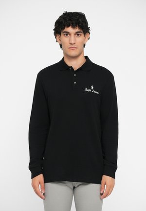 Zwarte langwerpige polo met lange mouwen, featuring een kraag, drie knopen en geborduurd logo op de borst; van zacht katoen.