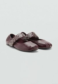 Burgundia nahka ballerinat pyöreällä varvaskärjellä, joissa on ristivarsi, johon on koristeltu hopeiset niitit. Sileä pinta, minimalistinen muotoilu.