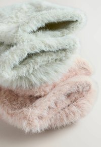 Zachte, pluche hoeden gestapeld, met zachte texturen. Kleuren zijn lichtgroen, lichtroze en perzik. Afgeronde randen met een dikke voering.