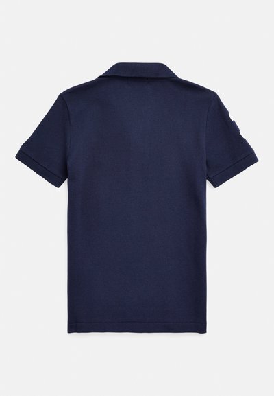 Námornícka modrá polokošeľa s krátkymi rukávmi, golierom a textúrovanou tkaninou. Pohľad zozadu ukazuje čisté šitie bez viditeľných log alebo ozdôb.