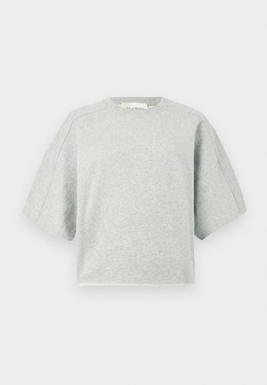 Ανοιχτό γκρι κοντό μπλουζάκι με φαρδιά μανίκια, σε συνδυασμό με ανοιχτό μπλε παντελόνι με φαρδιά μπατζάκια και καφέ μποτάκια αστραγάλου. Ομαλές υφές, άνετη εφαρμογή.