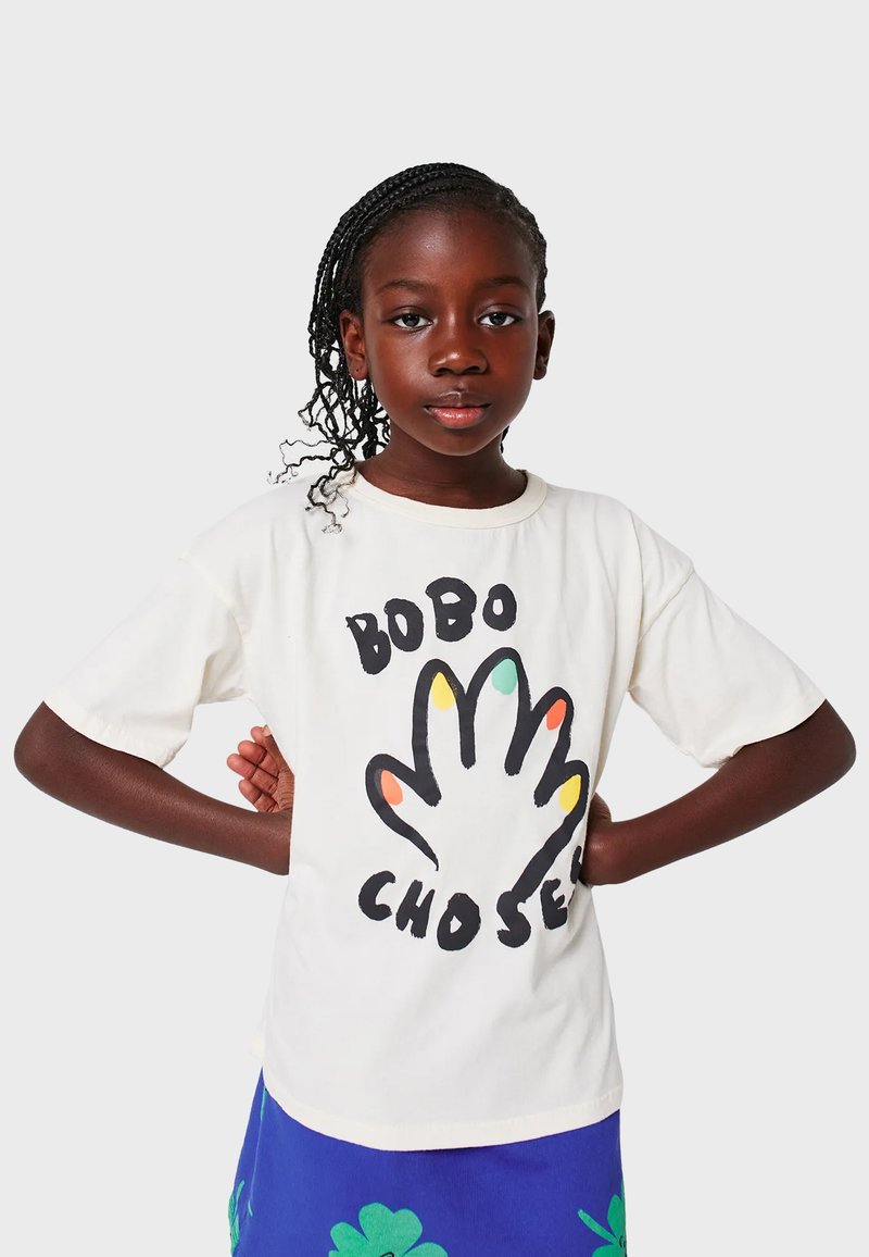 Cremfarbener T-Shirt mit einem Handgrafik, die farbenfrohe Fingerspitzen und fetten Text zeigt. Kurzärmlig, lockere Passform, aus weichem Baumwollmaterial.