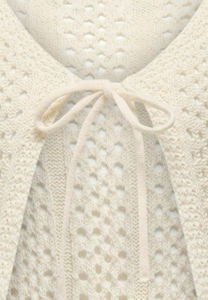 Licht crèmekleurige gebreide cardigan met een opengeweven ontwerp, gestrikt bij de hals met een koord van dezelfde stof. Voorzien van fijne, delicate patronen.