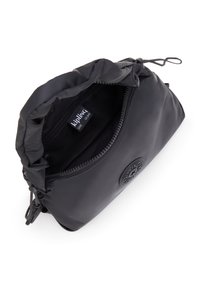 Sort pouch taske med en samlet top, lynlås-lukning, blød nylon yderside og et rundt logo-patch. Indersiden viser indvendig foret og mærkeetiket.