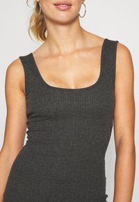 Dark gray sleeveless ribbed top with a square neckline, featuring a smooth texture and fitted design, ideal for layering or standalone wear.