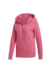 Růžová mikina na zip z měkké látky. Má kapuci, šňůrky a boční kapsy. Na hrudi je malý bílý logo.