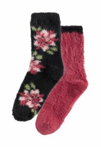 Pair of fuzzy socks, one solid dark pink and the other black with pink and green floral patterns.