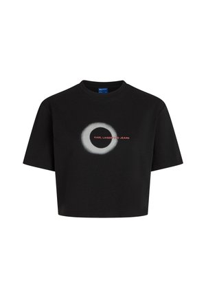 Černé zkrácené tričko vyrobené z bavlny, s krátkým rukávem. Uprostřed je bílý kruhový grafický prvek s červeným textem "KARL LAGERFELD JEANS."