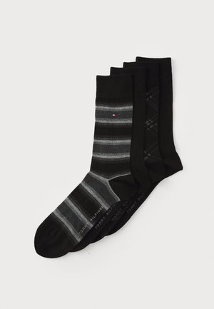 Set von vier Paar Socken in Schwarz und Grau. Die Merkmale umfassen zwei einfarbige schwarze Socken, eine grau-schwarze gestreifte Socke und eine schwarze Socke mit strukturiertem Muster.