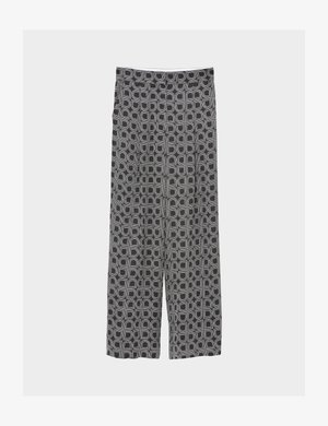 Platas legingu bikses ar melnbaltu ģeometrisku rakstu, kurā ir izliekta kvadrātu forma, attēlotas plakani uz gaiša fona.