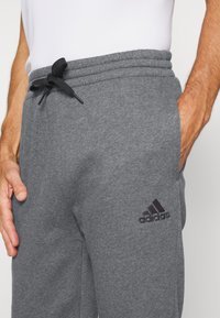 adidas Sportswear FEELCOZY - Pantalones deportivos - dark grey heather/black
