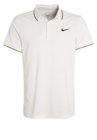 Biała koszulka polo wykonana z tkaniny odprowadzającej wilgoć. Posiada czarne logo Nike oraz kołnierzyk z neonowo-żółtymi i czarnymi akcentami.