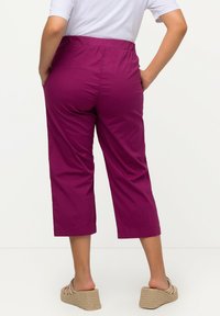 Fuchsia cropped broek met een elastische tailleband, een gladde textuur en zijzakken, gecombineerd met beige wedge sandalen.