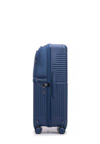 Valise rigide bleu marine avec des stries verticales, roues doubles, verrou à combinaison et fermeture éclair pour un rangement sécurisé.