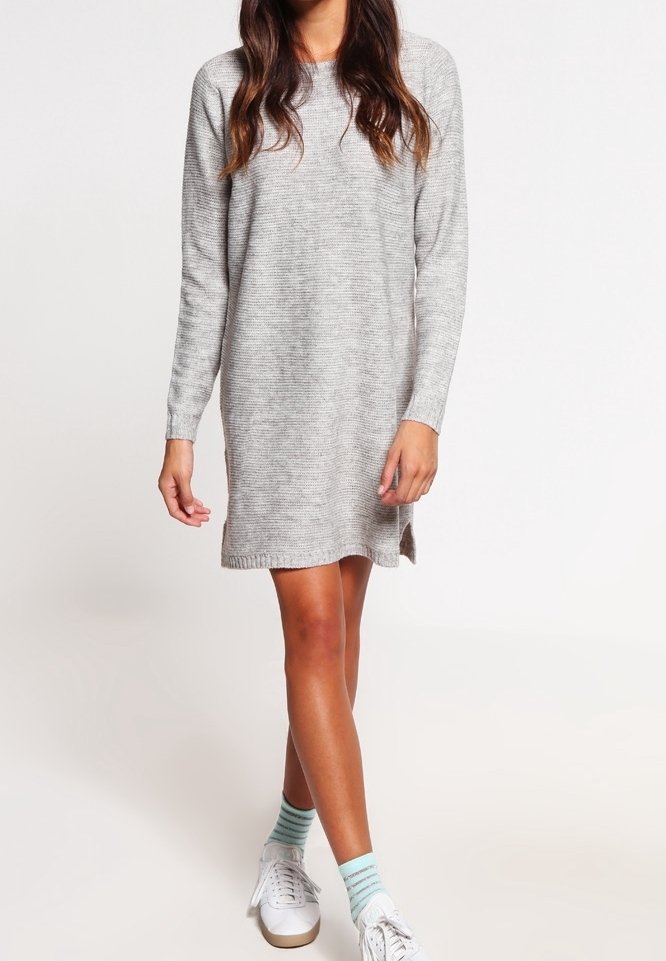 Ljusgrå stickad klänning med långa ärmar, sidoflikar och en avslappnad passform, som är kombinerad med vita sneakers och strumpor i mintgrön rand.