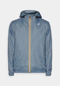 Helleblaue Windjacke mit Kapuze, versehen mit einem gelb-roten Streifen auf der Vorderseite, elastischen Bündchen und einem kleinen Logo auf der Brust.