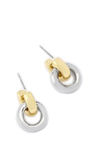 Boucles d'oreilles en métal doré et argenté avec un design circulaire, un fermoir articulé et une finition lisse et brillante.