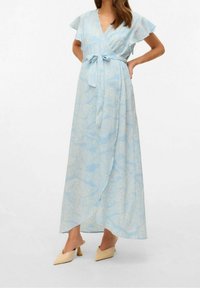 Abito maxi wrap di colore azzurro chiaro con maniche a drappo, tessuto strutturato e motivo floreale. Include una cintura di legatura e scende fino alla caviglia.