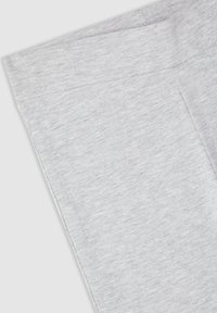 Primo piano di una manica in tessuto grigio chiaro con cuciture visibili e una morbida trama melangiata.