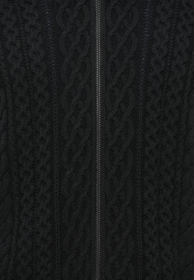 Cardigan noir en tricot avec un motif torsadé, fermeture éclair intégrale à l'avant et détails texturés. Le tissu semble doux et chaud.