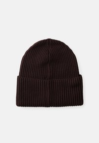 Gorra de punto marrón con textura acanalada, que presenta un puño doblado y una parte superior redondeada. Fabricada con un tejido suave y elástico.
