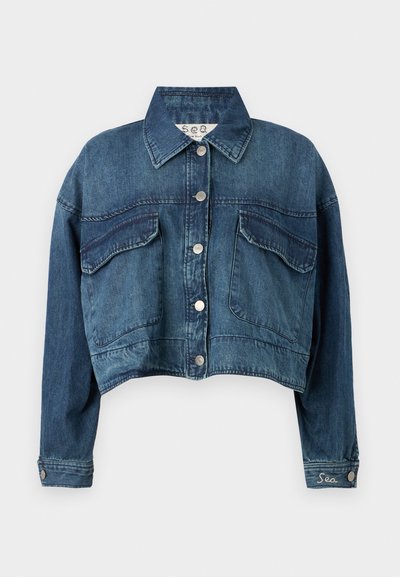 Kratka denim jakna v temno modri barvi, s katero sta vključena dve žepni žepi na prsih, srebrna gumbna zapirala in vezenina z napisom "Sea" na rokavu.