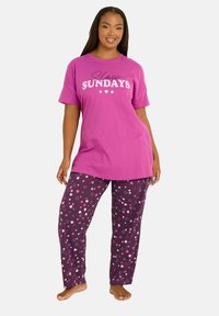 Vaaleanpunainen puuvillapaita, jossa on teksti "Hitaat sunnuntait". Tummanvioletit housut, joissa on vaaleanpunaisia ja valkoisia tähden ja sydämen kuvioita. Mukava, rento muotoilu.