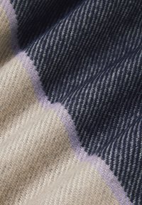 Tkanina wełniana z diagonalnym wzorem w paski, w kolorach granatowym, kremowym i lawendowym akcentem, prezentująca miękką, teksturowaną powierzchnię.