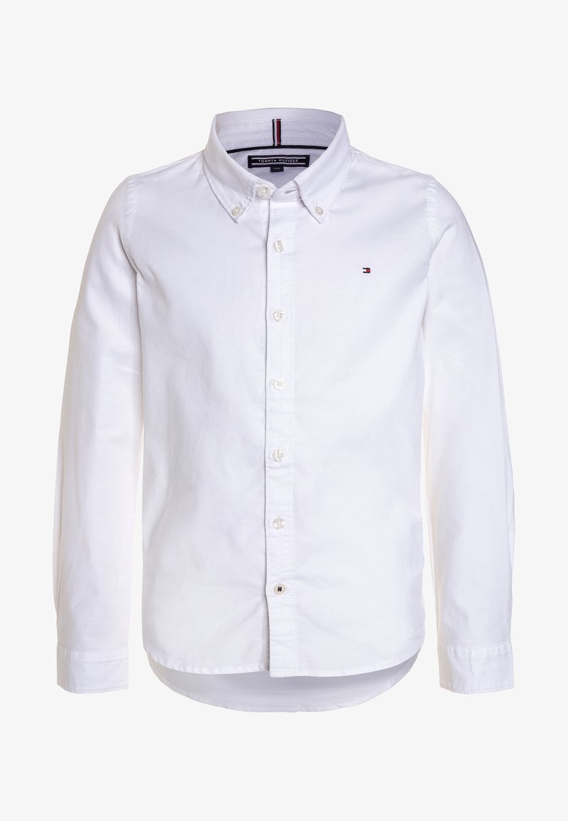 Chemise blanche à boutons avec un col classique, des manches longues et un petit logo sur la poitrine. Fabriquée en tissu lisse et léger.