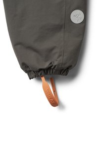 Grauer, leichter Jackenärmel mit elastischem Bund, ausgestattet mit einem runden Logo-Patch und einem orangefarbenen Zugband mit der Aufschrift "WHEAT". Leichte Textur.