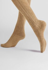 Light brown knee-high socks made of textured fabric featuring a ribbed design with a subtle pattern. Seamless toe and fitted heel.