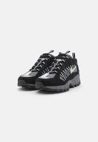 Și dresuri atletice negre și gri cu un superior din suede texturat, design distinctiv al panourilor, accente reflectorizante și talpă din cauciuc durabil.