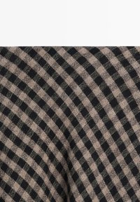 Wollmischgewebe mit diagonalem schwarz-beigem Karomuster, weicher Textur und dezentem Glanz.