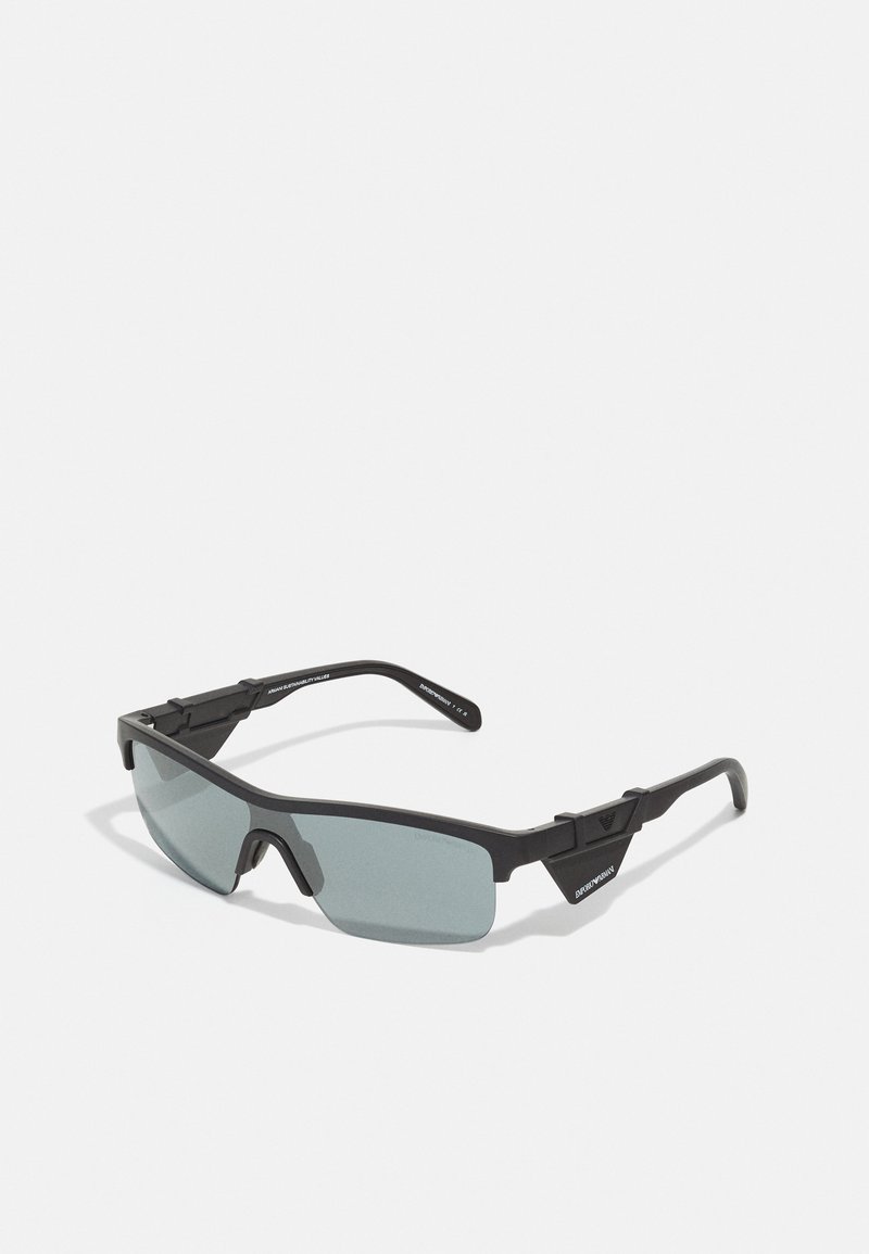 Ochelari de soare sport negri cu lentile gri, cadru unghiular, colțuri întărite și pernițe reglabile pentru un fit sigur.