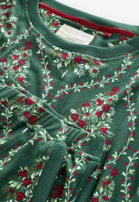 Hanorac verde cu un model floral în roșu și alb, cu guler rib mijlociu și textură moale. Eticheta spune "Laura Ashley."