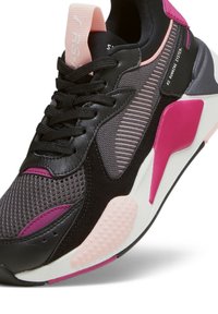 Baskets noires et grises avec textures en mesh et en daim, agrémentées d'accents roses. Design unique de la semelle avec des points en relief pour l'adhérence.