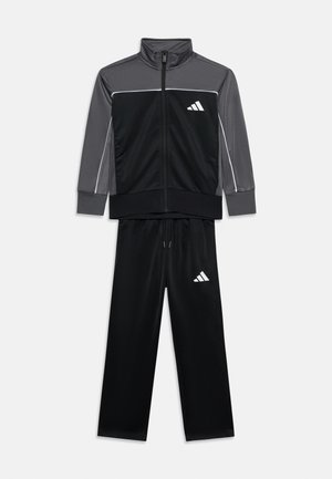 Laste must ja tumehall luku ja lukuga spordijope ning sobivad mustad paelaga spordipüksid, millel valge logo rinnal ja reiel.