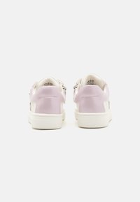 Hvite sneakers med en glatt rosa patent lær bak, teksturert hvit såle og dekorative detaljer på sidene. Flate snorer inkludert.