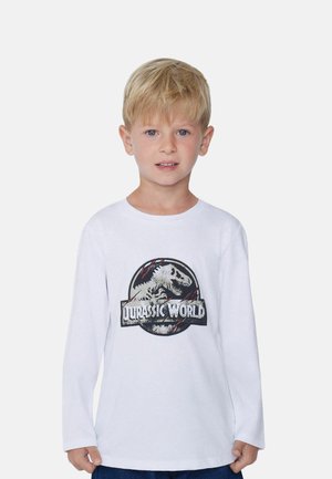 Biała T-shirt z długim rękawem, z graficznym nadrukiem dinozaura i napisem "Jurassic World" w czerni i czerwieni na przodzie.