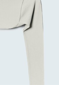 Lichtgrijs geribd cropped shirt met lange mouwen, met een gladde textuur en versterkte naden, gelegd op een lichte achtergrond.