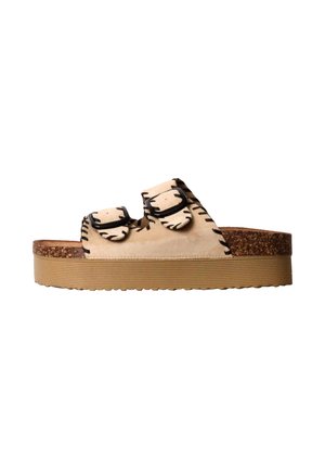 Sandale à plateforme beige avec deux brides réglables à boucle et des détails de couture noire sur une semelle épaisse et texturée.