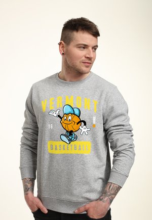 Šedá mikina s kreslenou postavou basketbalisty, žlutý text "VERMONT" a "BASKETBALL" tučným žlutým písmem na modrém pozadí.